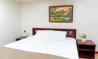 a bedroom with a white bed and a picture on the wall at Oro Apart Hotel in San Antonio