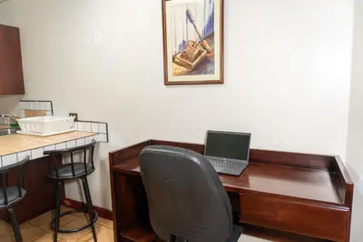 an office with a desk with a laptop computer on it at Oro Apart Hotel in San Antonio