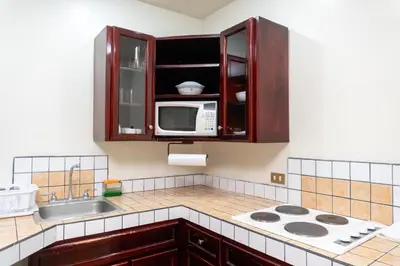 a kitchen with a sink and a microwave at Oro Apart Hotel in San Antonio