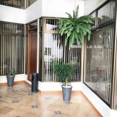 a lobby with two potted plants in front of a building at Oro Apart Hotel in San Antonio