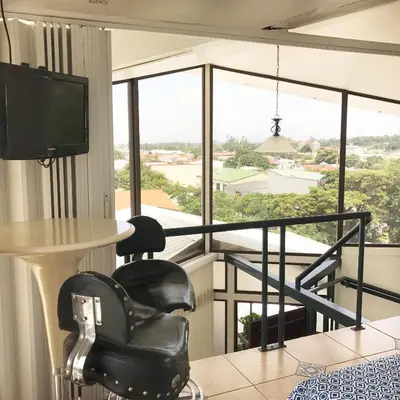 a room with a table and chairs and a large window at Oro Apart Hotel in San Antonio