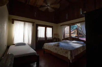a bedroom with two beds and a window at Princesa de la Luna Ecolodge in Fortuna