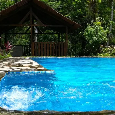 a pool with a gazebo and blue water at Princesa de la Luna Ecolodge in Fortuna