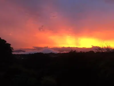 a sunset with a rainbow in the sky at Uruka Lodge in Alajuela City