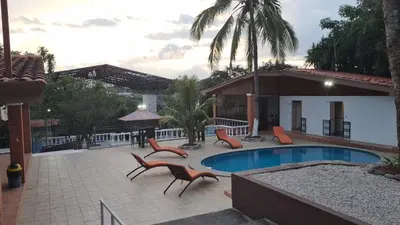 a patio with chairs and a swimming pool at Uruka Lodge in Alajuela City