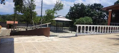 a patio with a white railing and an umbrella at Uruka Lodge in Alajuela City