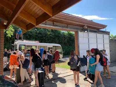 a group of people waiting to get on a bus at Uruka Lodge in Alajuela City