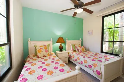 a bedroom with two beds and a ceiling fan at Colorful 3-BD Unit Opening on Pool in Coco