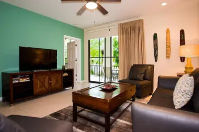a living room with a tv and a couch and a table at Colorful 3-BD Unit Opening on Pool in Coco
