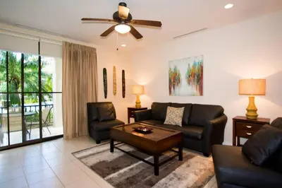a living room with a couch and chairs and a ceiling fan at Colorful 3-BD Unit Opening on Pool in Coco