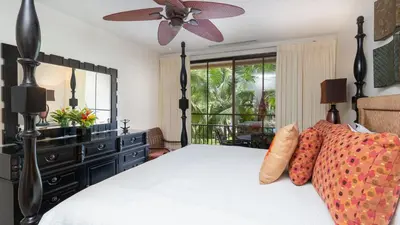 a bedroom with a bed and a ceiling fan at 1-Bedroom Near Pool in Coco