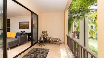 a living room with a couch and a chair at 1-Bedroom Near Pool in Coco