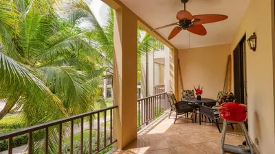 a balcony with a table and a ceiling fan at 1-Bedroom Near Pool in Coco