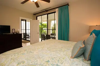 a bedroom with a large bed with blue pillows at Nicely Decorated 3rd-Floor Beauty with Pool-View Balcony in Coco in Coco