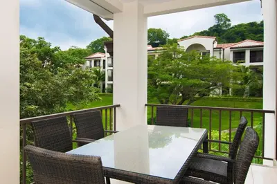a patio with a table and chairs on a balcony at Nicely Decorated 3rd-Floor Beauty with Pool-View Balcony in Coco in Coco