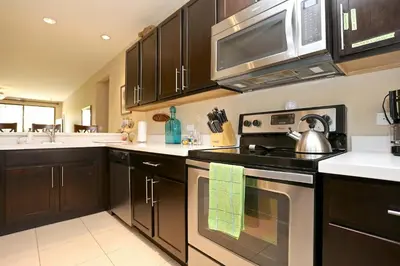 a kitchen with a stove and a microwave at Nicely Decorated 3rd-Floor Beauty with Pool-View Balcony in Coco in Coco