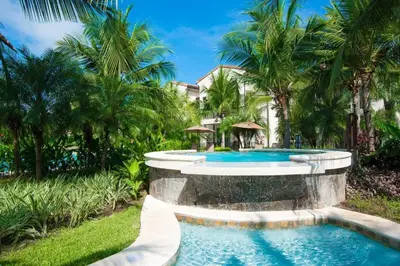 a swimming pool in a resort with palm trees at Impressively designed and decorated 3rd-floor space overlooking pool in Coco in Coco