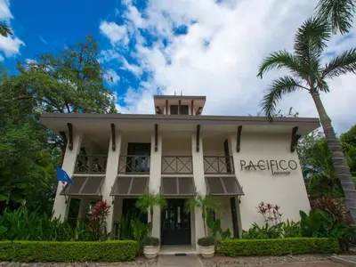 a building with a palm tree in front of it at Impressively designed and decorated 3rd-floor space overlooking pool in Coco in Coco