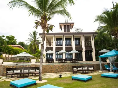 a resort with benches and umbrellas in front of it at Impressively designed and decorated 3rd-floor space overlooking pool in Coco in Coco
