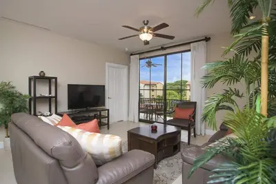 a living room with a couch and a television at Impressively designed and decorated 3rd-floor space overlooking pool in Coco in Coco