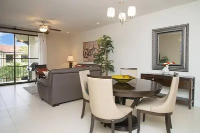 a dining room with a table and a couch at Impressively designed and decorated 3rd-floor space overlooking pool in Coco in Coco