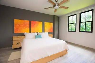 a bedroom with a white bed and a ceiling fan at Chic Minimalist Condo with Swimming Pool, Hot Tub, and Beach Club Access in Coco