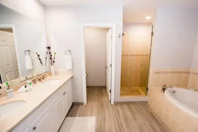 a bathroom with two sinks and a tub and a shower at Chic Minimalist Condo with Swimming Pool, Hot Tub, and Beach Club Access in Coco