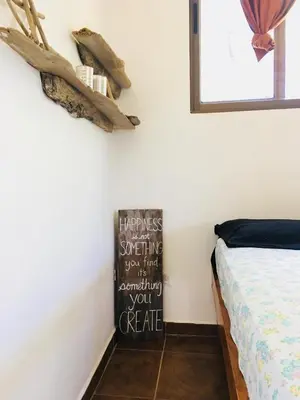 a bedroom with a bed and a sign on the wall at Mundaka : Burnt Toast Surfcamp in Nosara