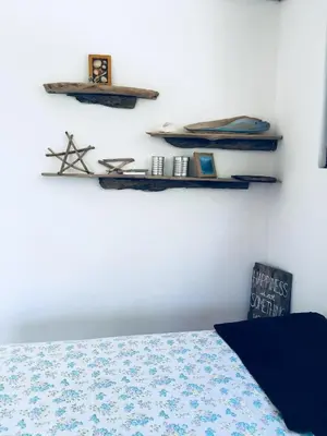 a bedroom with a bed and shelves on the wall at Mundaka : Burnt Toast Surfcamp in Nosara