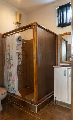 a shower with a wooden door in a bathroom at Mundaka : Burnt Toast Surfcamp in Nosara