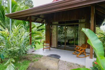 a house with two chairs sitting on a porch at Hotel Volcan Verde in Fortuna