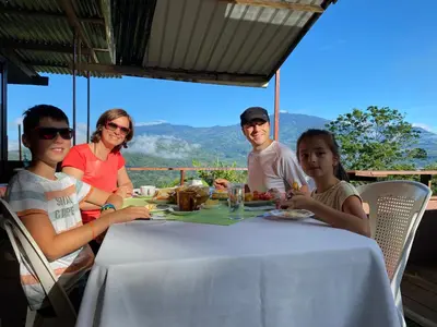 a group of people sitting at a table eating food at Bella Vista Ranch Ecolodge in Turrialba