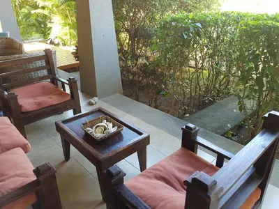 a porch with two chairs and a table with a coffee table at Casa Claudia in Potrero