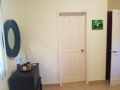 a hallway with a white door and a mirror at Casa Claudia in Potrero