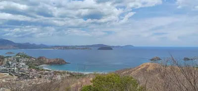 a large body of water with a town on a hill at Las Catalinas Loft - for up to 4 people just steps from the beach in Playa Danta