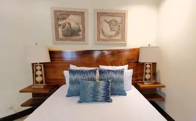 a bedroom with a bed with blue and white pillows at Las Catalinas Loft - for up to 4 people just steps from the beach in Playa Danta