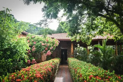a house with a garden with flowers in front of it at Casa Cora Bed and Breakfast in Colonia Carmona