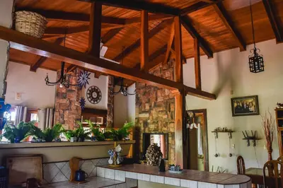 a living room with a table and a stone fireplace at Casa Cora Bed and Breakfast in Colonia Carmona