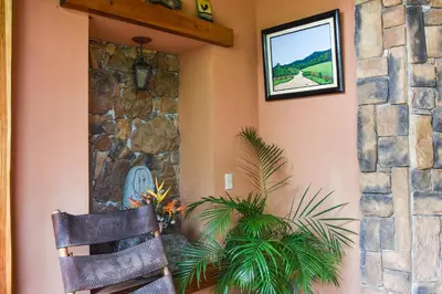a room with a chair and a stone wall at Casa Cora Bed and Breakfast in Colonia Carmona
