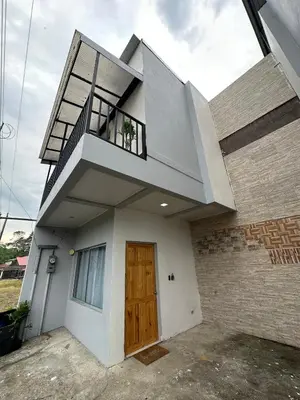 a house with a wooden door and a balcony at Punta Leona Beach Condos in Jacó
