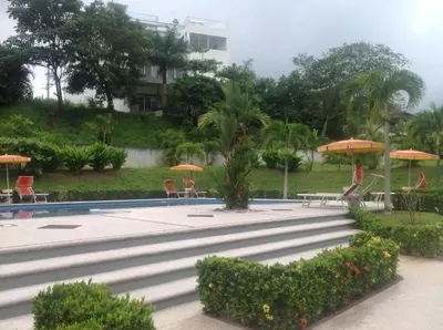 a pool with tables and chairs and umbrellas at Punta Leona Beach Condos in Jacó