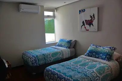 a room with two beds and a window at Luxury Beach Apartment Herradura Fishermen And Family in Herradura