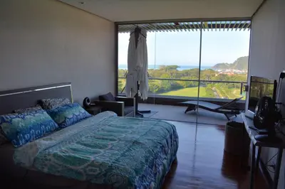 a bedroom with a bed and a large window at Luxury Beach Apartment Herradura Fishermen And Family in Herradura