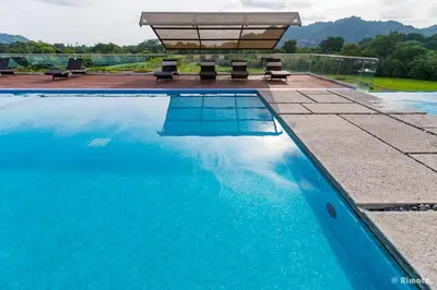 a swimming pool with two benches and a table at Luxury Beach Apartment Herradura Fishermen And Family in Herradura