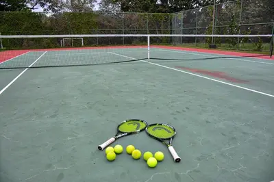 a tennis racket and balls on a tennis court at Luxury Beach Apartment Herradura Fishermen And Family in Herradura