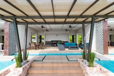 a swimming pool with a patio and a pool house at Luxury Beach Apartment Herradura Fishermen And Family in Herradura