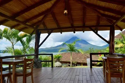 a wooden porch with a view of a mountain at Pie In The Sky 3 Stunning Lake & Volcano Views! in El Castillo de La Fortuna