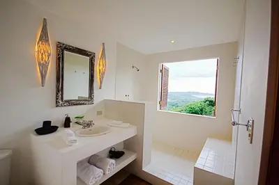 a white bathroom with a sink and a window at Tierra Magnifica Boutique Hotel in Nosara