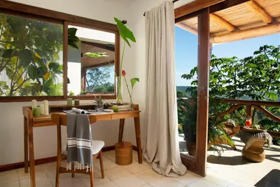 a home office with a desk and large windows at Tierra Magnifica Boutique Hotel in Nosara