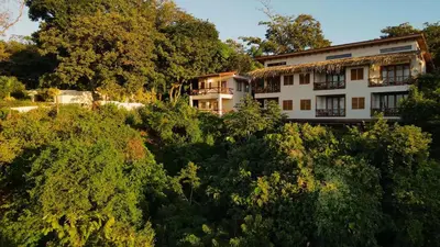 an apartment building in the middle of trees at Tierra Magnifica Boutique Hotel in Nosara